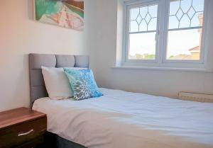 a bedroom with a bed with a pillow and a window at Airport Lounge - 3 Bed - 6 Persons in Manchester