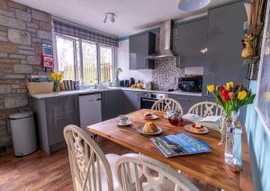 une cuisine avec une table et des chaises en bois dans l'établissement Ocean Cottage, à Uny Lelant