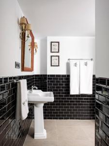 a bathroom with black and white tiles and a sink at VAC LUXURY HOME SEVILLA in Seville +36 photos