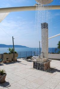 een fontein op een patio met uitzicht op het water bij Villa I Cipressi - Rebomaholidays in Toscolano Maderno