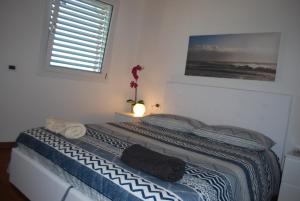 een slaapkamer met een bed met een deken en een raam bij Villa I Cipressi - Rebomaholidays in Toscolano Maderno
