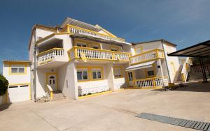 a large white house with balconies on top of it at Apartments Klaric in Pirovac