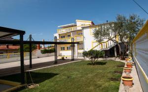 a view of a yard with a building at Apartments Klaric in Pirovac