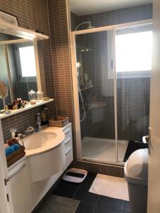 uma casa de banho com um lavatório e um chuveiro em Carpe Diem em Le Val-André