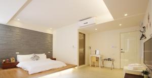 una camera da letto con un letto bianco e un muro di mattoni di 幸福圓點新北市民宿220號 a Tamsui