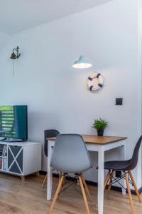 een kamer met een tafel en stoelen en een televisie bij Apartament Zeglarski in Powidz
