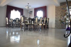 a dining room with a table and chairs and a christmas tree at Casa Dumitru in Ceraşul