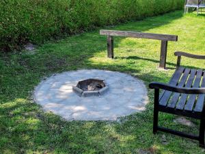 a fire pit sitting next to a park bench and a park at 12 person holiday home in Nordborg in Nordborg