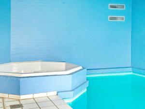 a blue bathroom with a tub in a swimming pool at 12 person holiday home in Nordborg in Nordborg