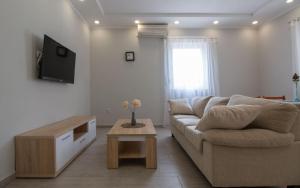 ein Wohnzimmer mit einem Sofa und einem Couchtisch in der Unterkunft Apartments Klaric in Pirovac