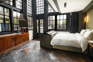 a bedroom with a bed with a suitcase in it at Boutique Hotel The Craftsmen in Amsterdam