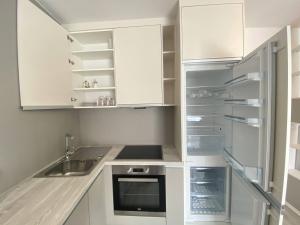 a kitchen with white cabinets and a sink at Seven days Smíchov in Prague
