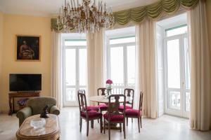 a dining room with a table and chairs and a chandelier at Casa Bellevue in Naples