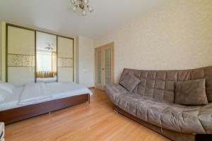 Un dormitorio con sofá y cama. en Apartments on Ploscha Yakuba Kolasa en Minsk