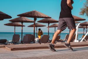 a man walking along a beach with umbrellas at Golden Star City Resort in Perea