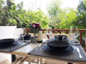 a table with plates and glasses and a bottle of wine at Alexandra Apartments in Skala Fourkas