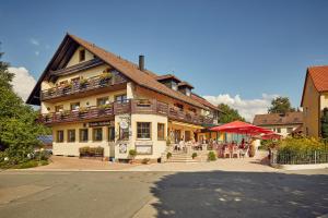 a building with people sitting on the balconies of it at Hotel Schloßberg in Gräfenberg