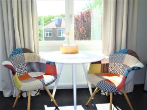 twee stoelen en een witte tafel voor een raam bij Studio het Strandhuis KA04 in Vlissingen