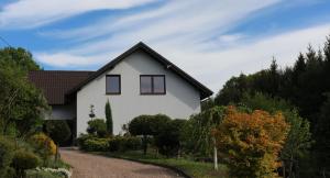 a white house with a gravel driveway at Apartamenty Leszczynowa 7 blisko Zatora in Spytkowice