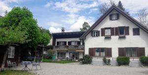 une grande maison blanche avec une véranda et un arbre dans l'établissement Ferienwohnungen Haus Unterberger, à Bad Ischl