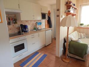 eine Küche mit weißen Schränken und einer Lampe in einem Zimmer in der Unterkunft Schwedenhaus Raich in Kleines Wiesental