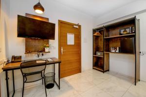 a kitchen with a desk with a chair and a door at South Wind Guesthouse in Marsaxlokk