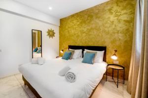 1 dormitorio con 1 cama blanca grande con almohadas azules en South Wind Guesthouse, en Marsaxlokk
