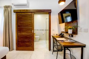 un bagno con porta in legno e una scrivania con lavandino di South Wind Guesthouse a Marsaxlokk