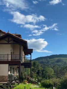 uma casa com uma varanda numa colina em Hotel Rural Playa de Aguilar em Muros de Nalón