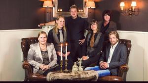 een groep mensen die rond een tafel met kaarsen zitten bij Parkhotel Hugo de Vries in Lunteren