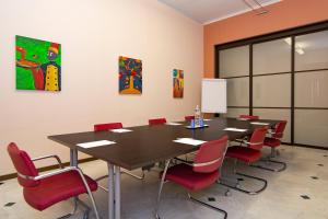 einen Konferenzraum mit einem Tisch und roten Stühlen in der Unterkunft V12 Apartments - Vittoria 12 in Novara