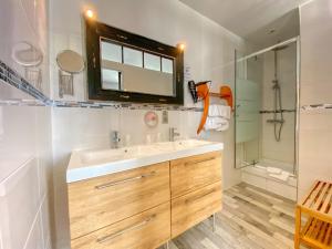 a bathroom with a sink and a shower and a mirror at Hôtel Le P'tit Monde in Montignac +61 photos