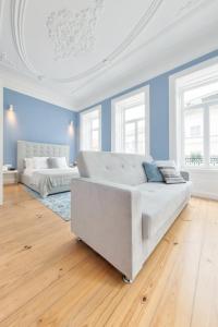 Sofá blanco en habitación azul con 2 camas en Aveiro History Apartments, en Aveiro