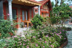 a garden in front of a house with flowers at Tam Coc Family Homestay in Ninh Binh