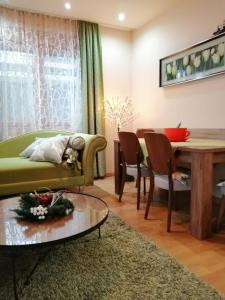 een woonkamer met een groene bank en een tafel bij Zlatibor lux Kalman in Zlatibor