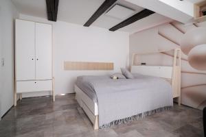 a bedroom with a bed and a white wall at Design-Ferienwohnungen Stadtidyll in Wernigerode