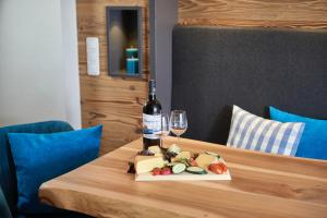 eine Flasche Wein und ein Teller mit Essen auf dem Tisch in der Unterkunft Alpvilla Bietsch in Oberstdorf