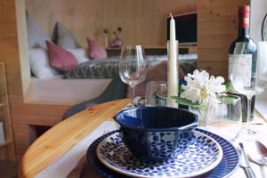 a table with a blue and white bowl and wine glasses at Igluhut Tiny House Bayerischer Wald in Zachenberg