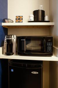 a microwave sitting on a shelf in a kitchen at Holiday Inn Express & Suites Downtown Louisville, an IHG Hotel in Louisville