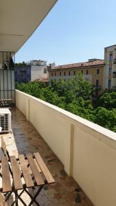 una panca di legno seduta in cima a un balcone di AMAVERONA APARTMENT a Verona