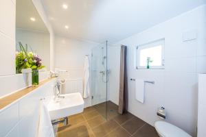 a white bathroom with a sink and a shower at fjord hotel berlin in Berlin +42 photos