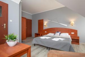 ein Schlafzimmer mit einem großen Bett und einem Tisch in der Unterkunft Villa Livia in Niechorze