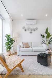 a white living room with a couch and a table at Casa Boma Lisboa - Design and Sunny Apartment - Lapa I in Lisbon