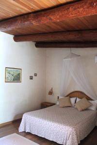 una camera con letto e soffitto in legno di La Petrusa a Vernole