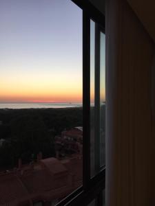 einen Sonnenuntergang aus einem Fenster in einem Gebäude in der Unterkunft São João Beach Lounge in Costa da Caparica