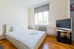 a bedroom with a bed and a flat screen tv at In the center of Minsk in Minsk