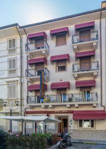 un edificio con balconi e uno scooter parcheggiato di fronte di Hotel Dolly a Viareggio