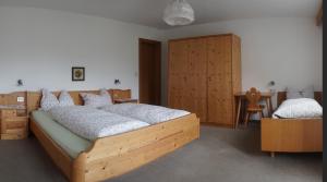 a bedroom with a wooden bed and a desk at Agriturismo Gfaderhof in Bressanone