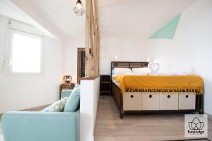 um quarto com uma cama e um sofá em Le Vetiver 3 étoiles - 30m2 - Rénové avec vue mer - 10' de l'aéroport em Sainte-Clotilde