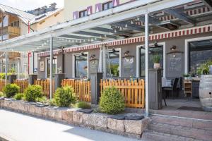 a restaurant with awning and plants in front of it at Hotel Seehof in Zell am See